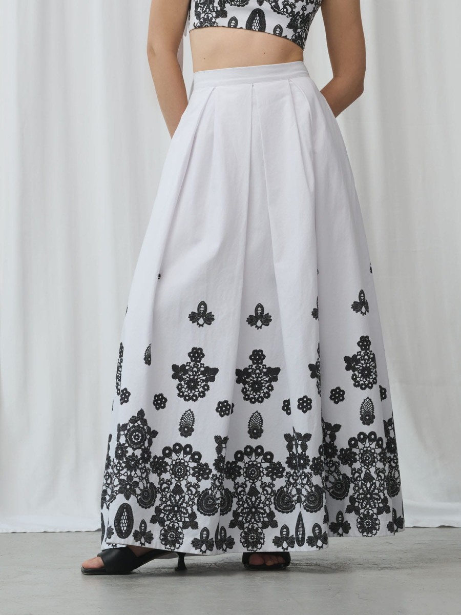 Rozkloszowana bawełniana spódnica z zakładkami i czarnym printem – detal przodu.