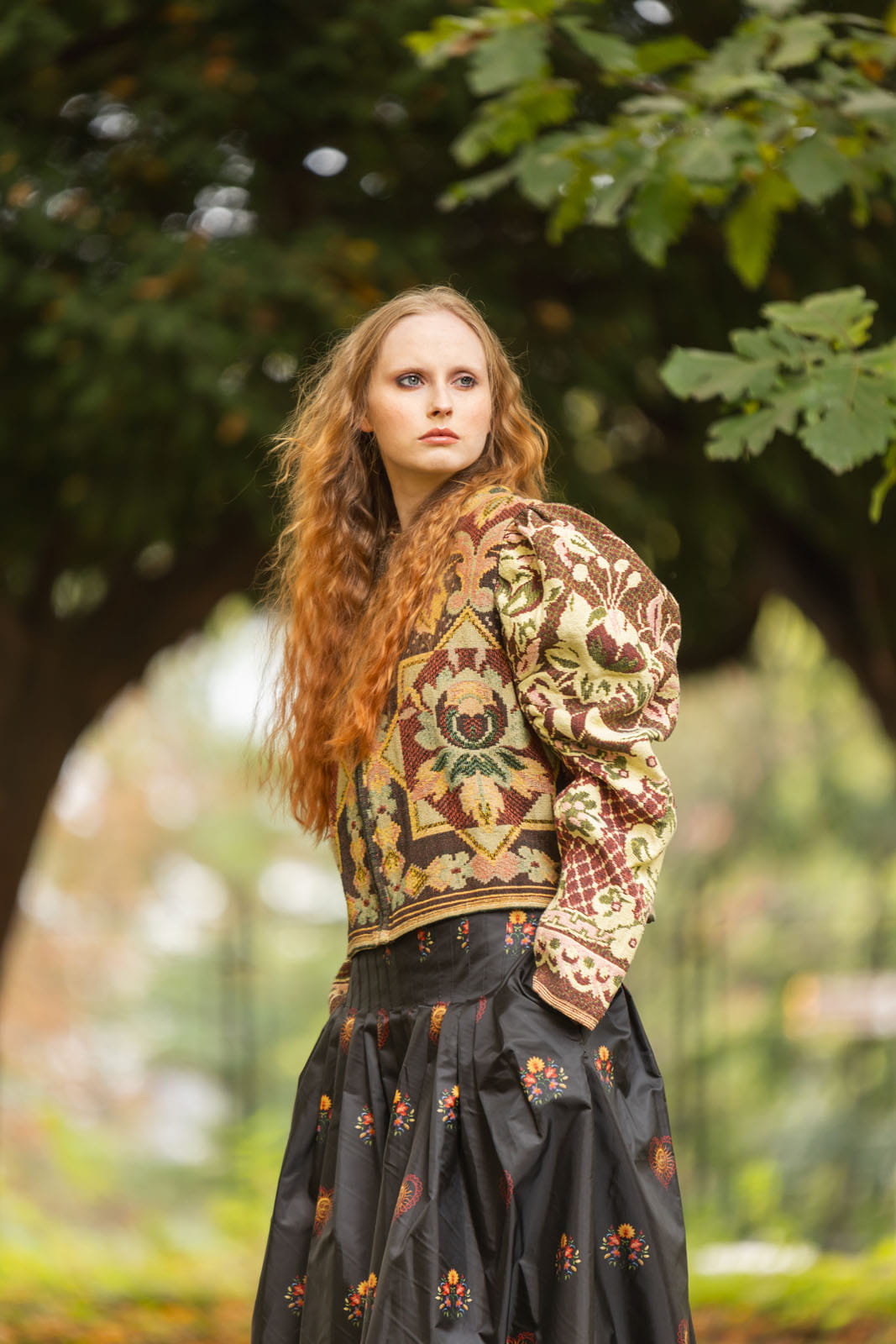 Czarna spódnica Antonina maxi z zakładkami na wysokości bioder i widoczną kieszenią po boku.