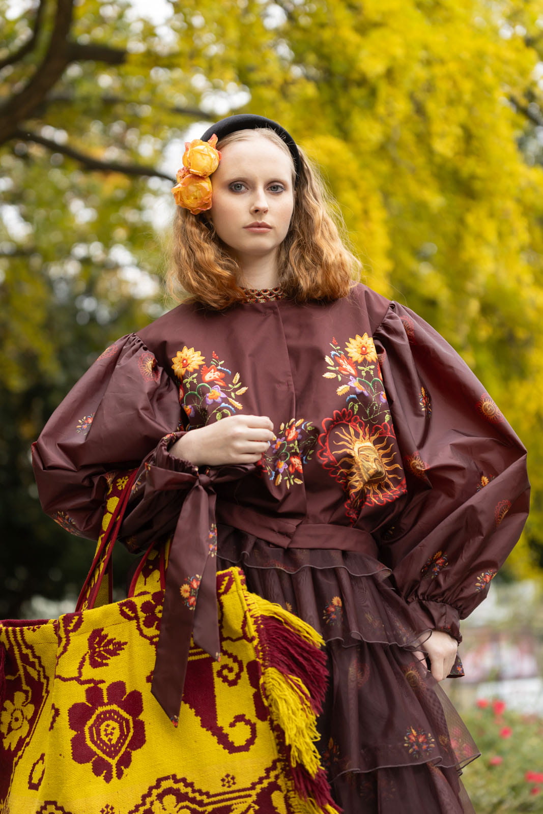 Kurtka Folk marsala – stylizacyjne ujęcie w ogrodzie, widoczne elementy kwiatowego printu.
